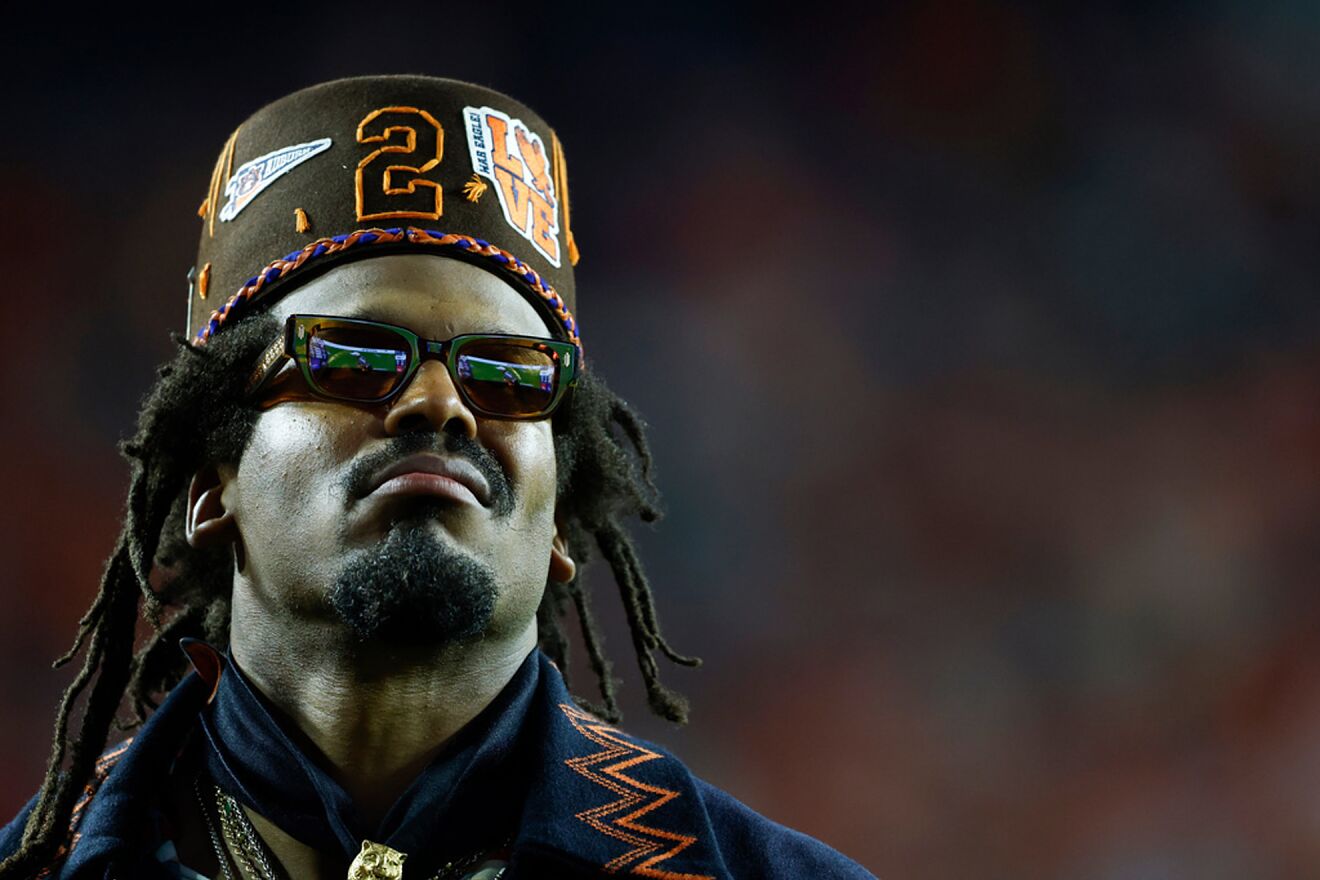 Former Auburn quarterback and NFL player Cam Newton watches a play...