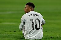 Mbapp�, sentado en el c�sped durante un partido con gesto serio.