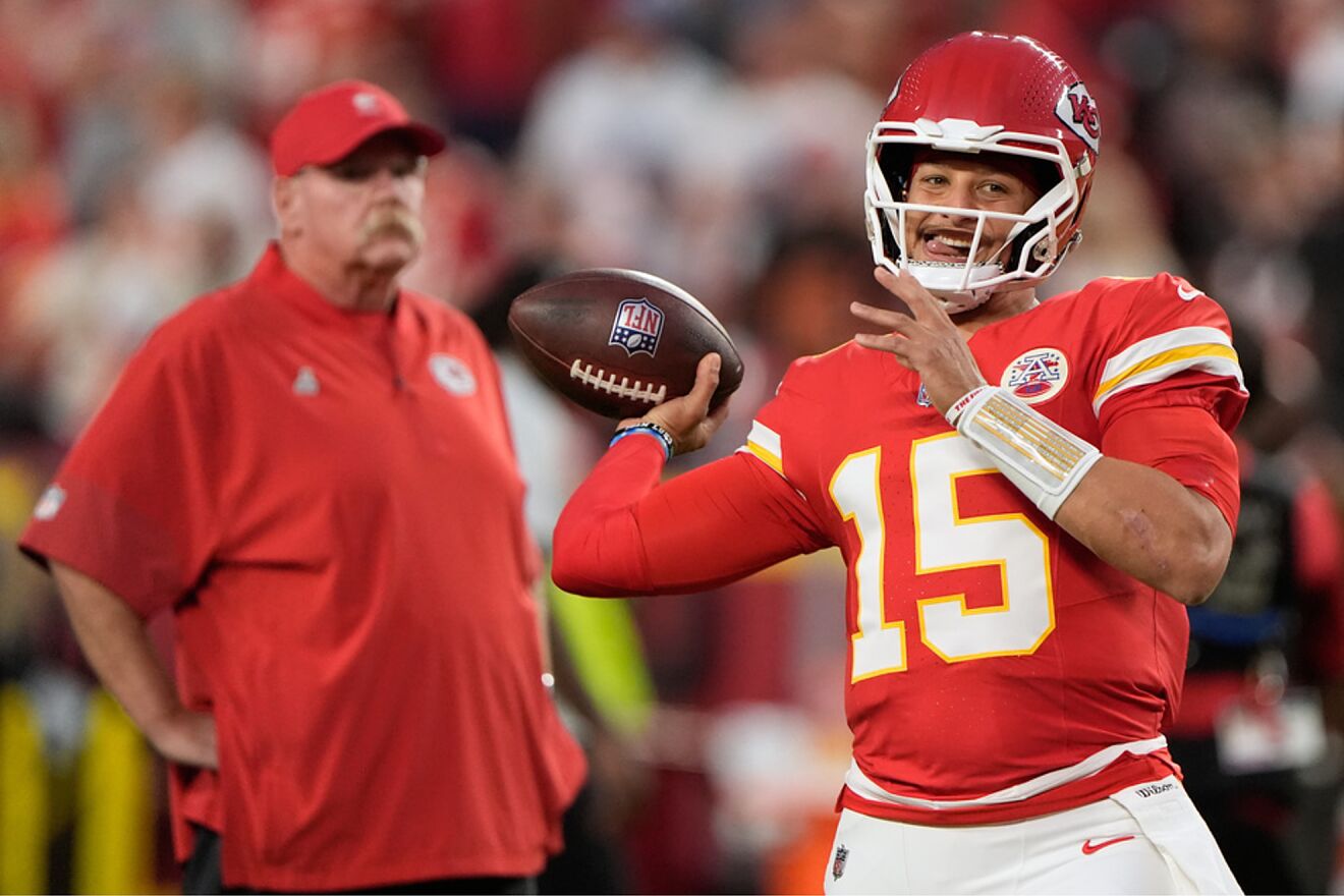 Andy Reid looks on as Patrick Mahomes throws a pass during warmups...