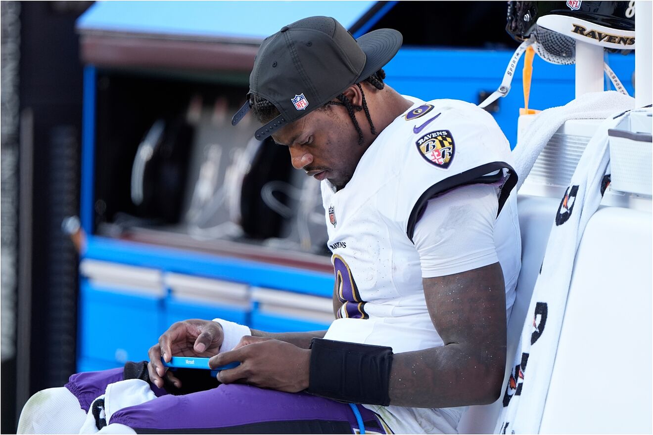Baltimore Ravens quarterback Lamar Jackson sits on the bench after...