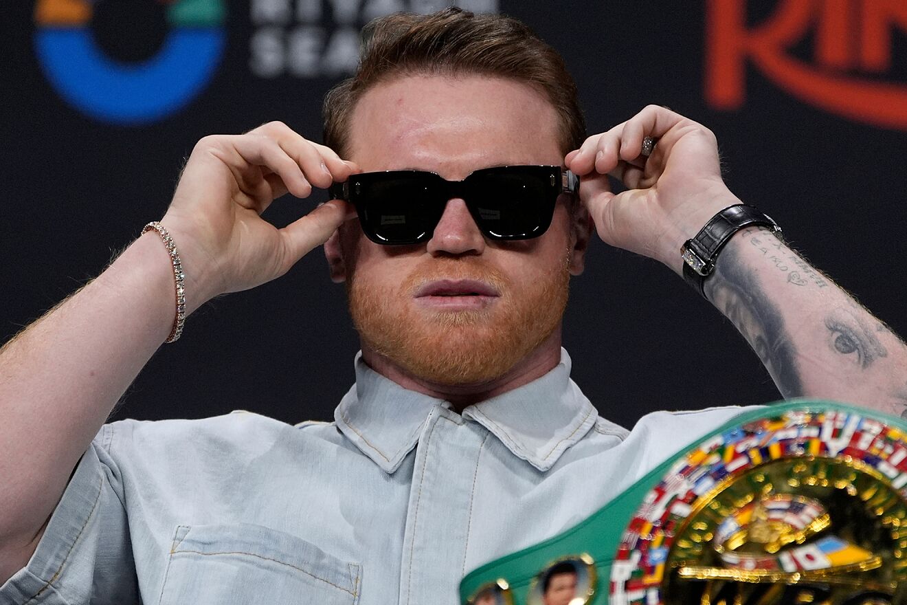 Canelo Alvarez fixes his sunglasses during a press conference...