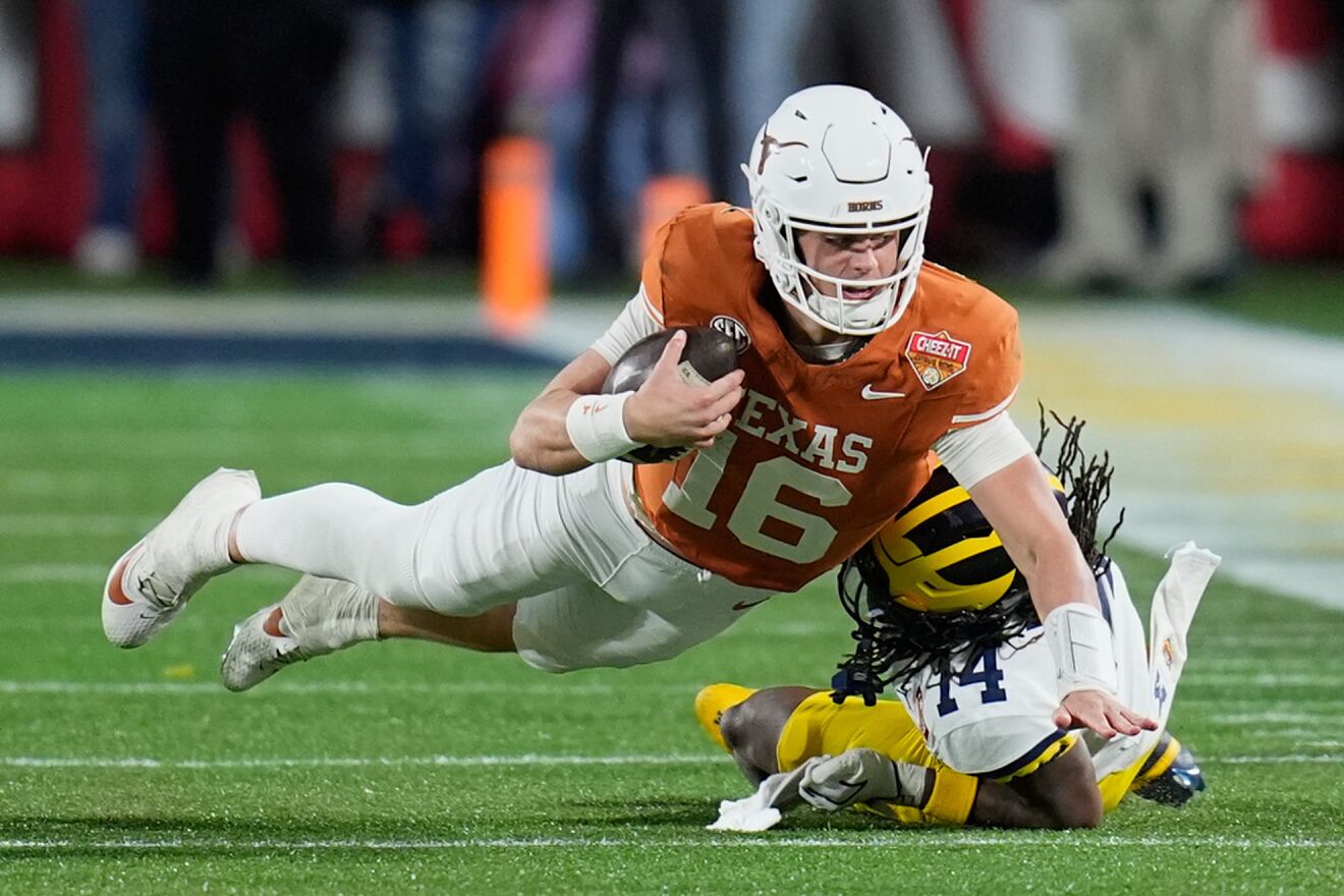 Texas quarterback Arch Manning (16) dives as he is tackled by Michigan...