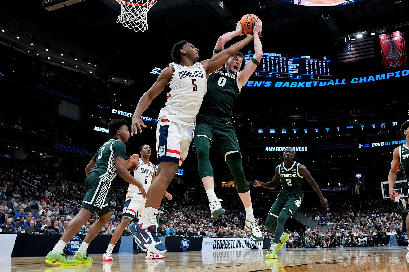 Michigan State forward Jaxon Kohler (0) rebounds over UConn forward...