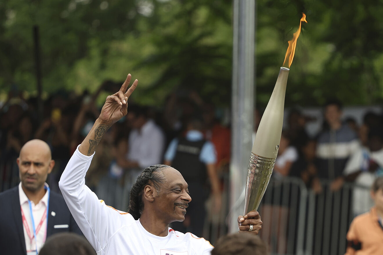 Snoop Dogg carries the Olympic torch at the 2024 Summer Olympics