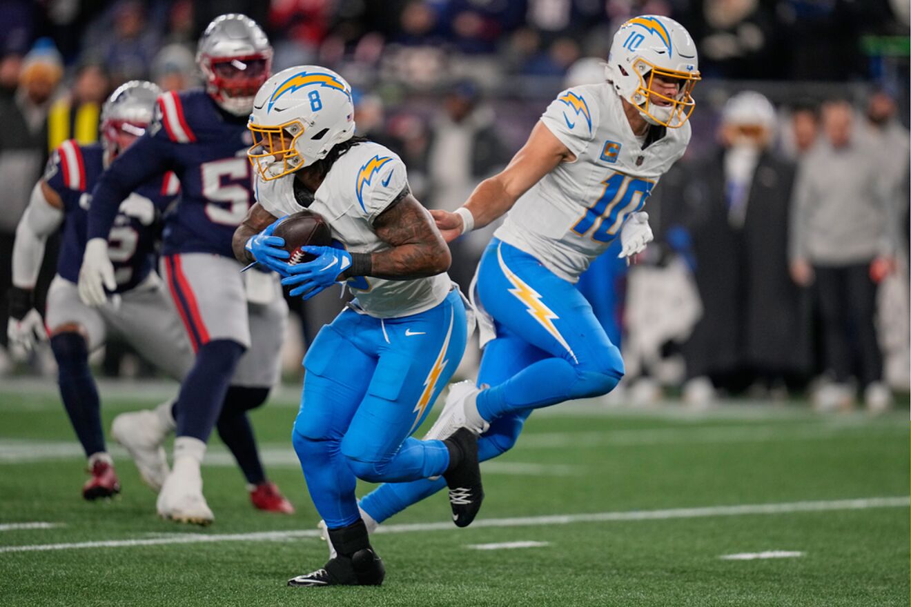 Los Angeles Chargers quarterback Justin Herbert (10) hands off to...