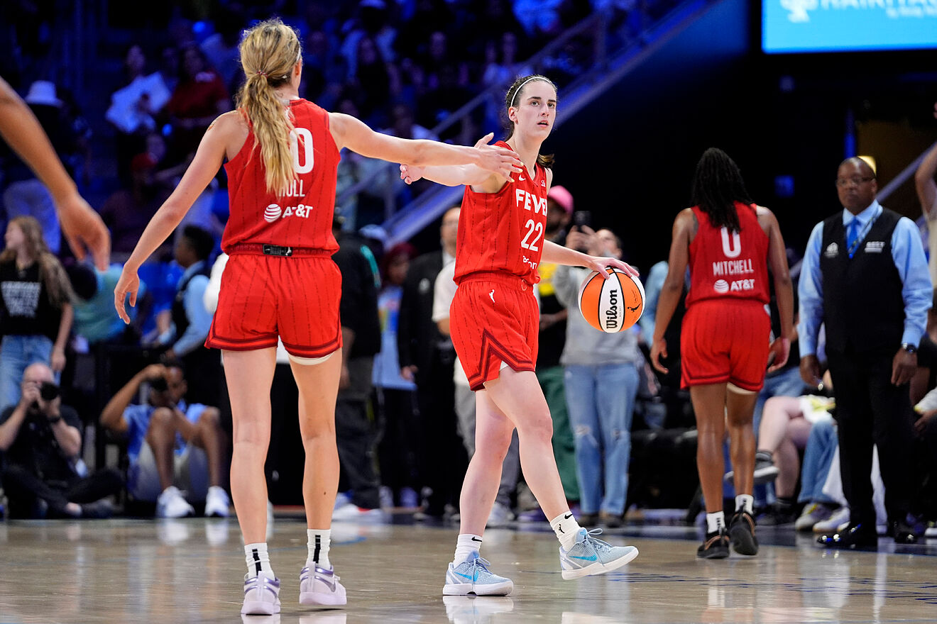Indiana Fever's Lexie Hull (10) and Caitlin Clark, center, celebrate...