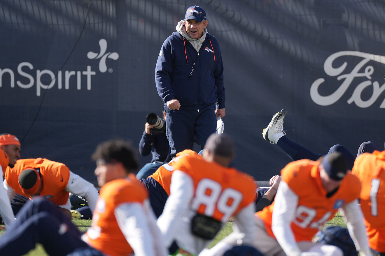 Denver Broncos head coach Sean Payton chats with players as they...