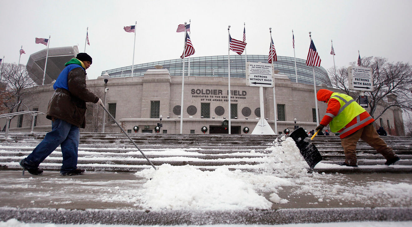 Workers clearing the steps at Soldier Field during a winter storm in...