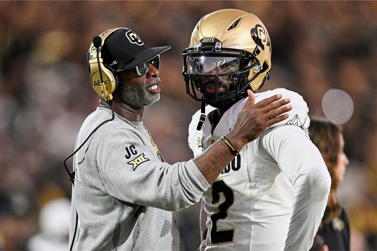 Deion Sanders consoles Shedeur Sanders during a game.