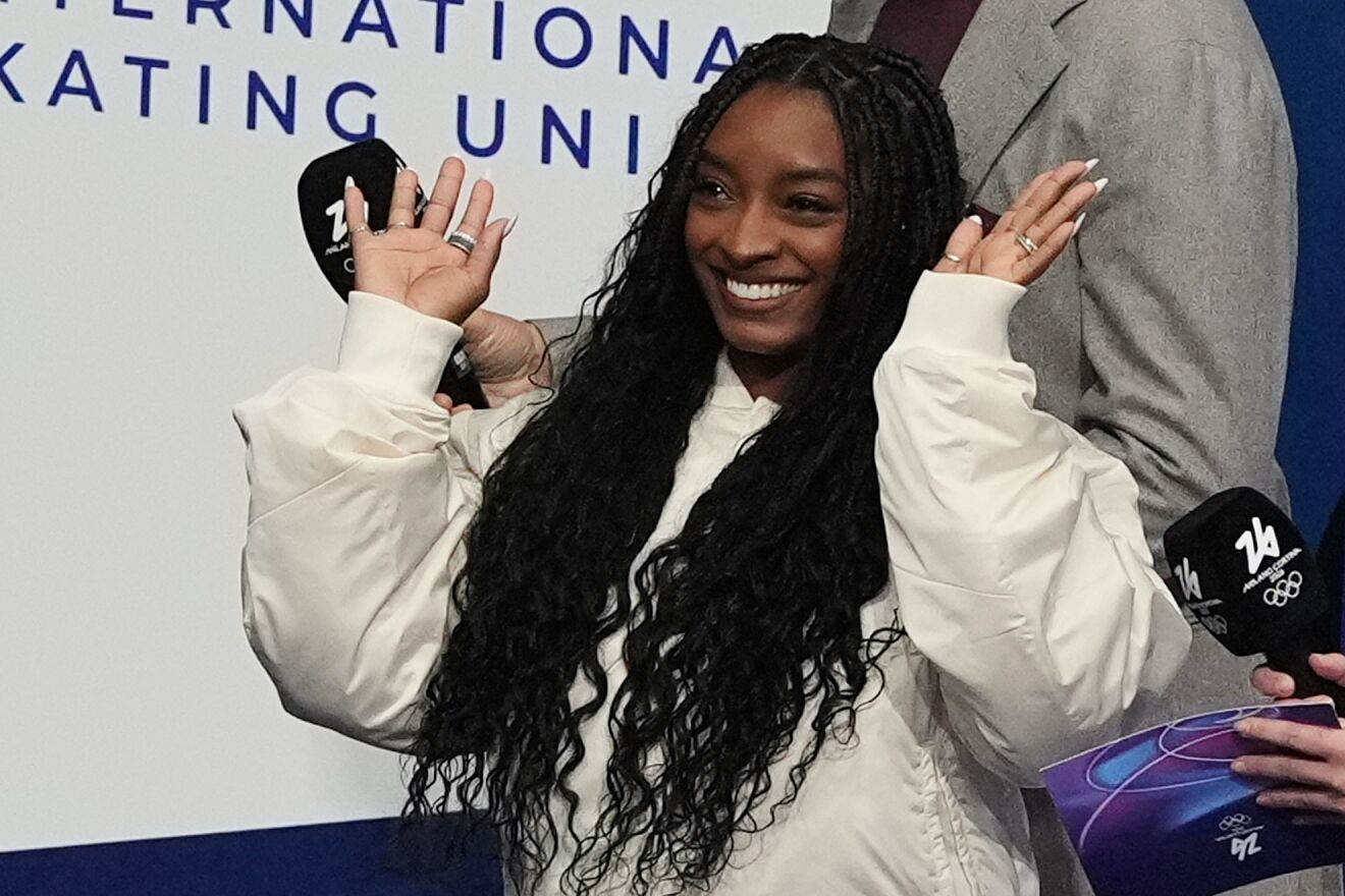 Biles watches competes the men's free skate program in figure skating...