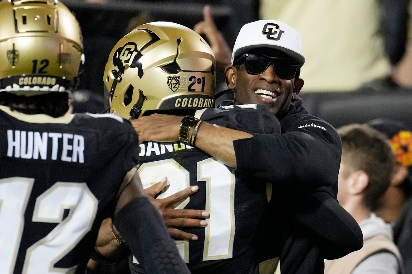 Deion Sanders hugs one of his sons.
