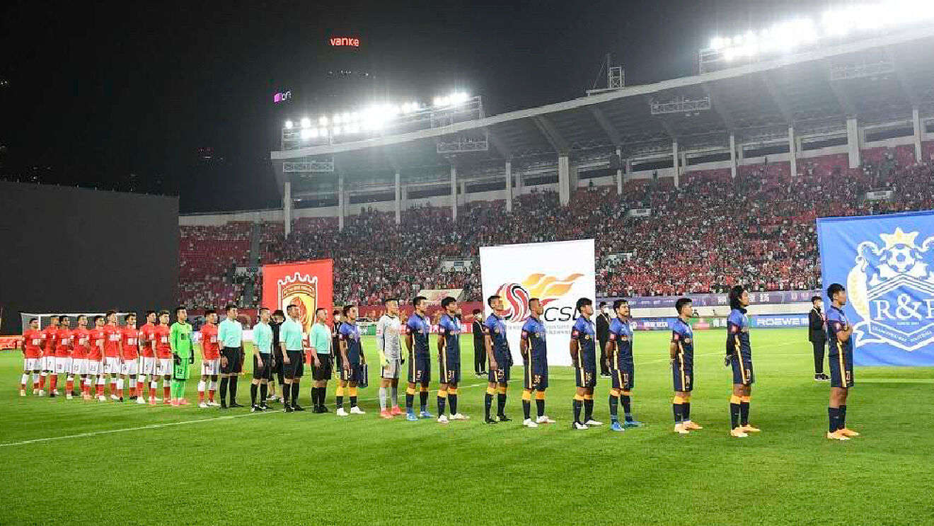 Los onces de Guangzhou FC y Guangzhou City escuchan el himno en la...