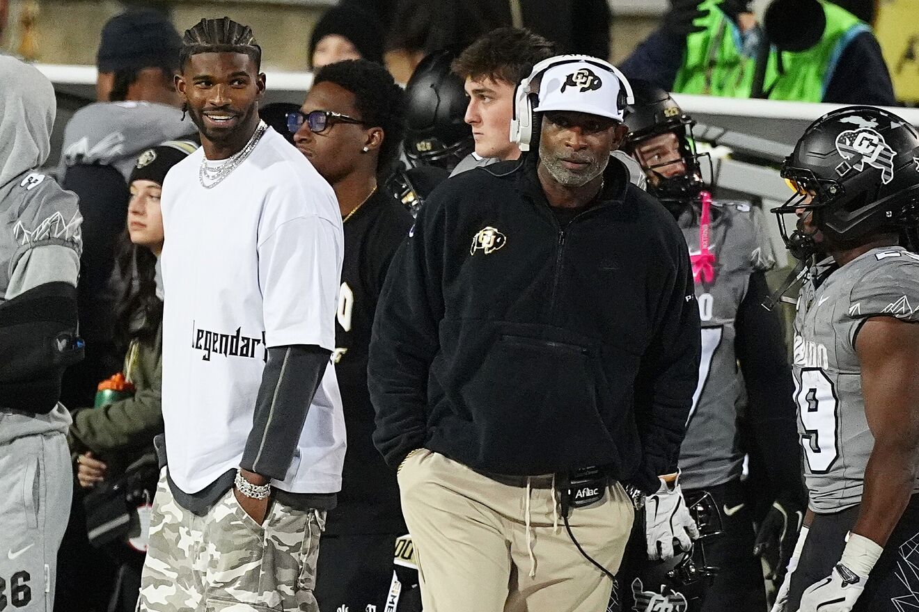 Cleveland Browns quarterback Shedeur Sanders, left, jokes with his...