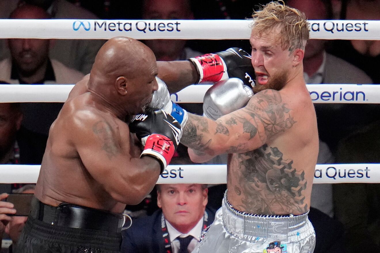 Mike Tyson hits Jake Paul during their heavyweight boxing match.