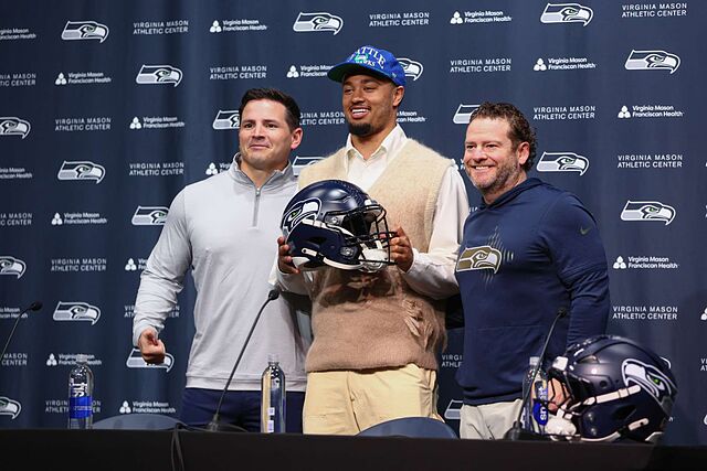 Seattle Seahawks head coach Mike Macdonald, from left, wide receiver Jaxon Smith-Njigba (11), and general manager John Schneider pose for a photo