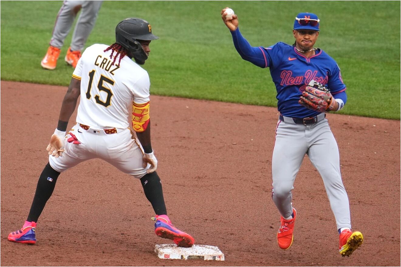 New York Mets shortstop Francisco Lindor, right, fakes a throw while...
