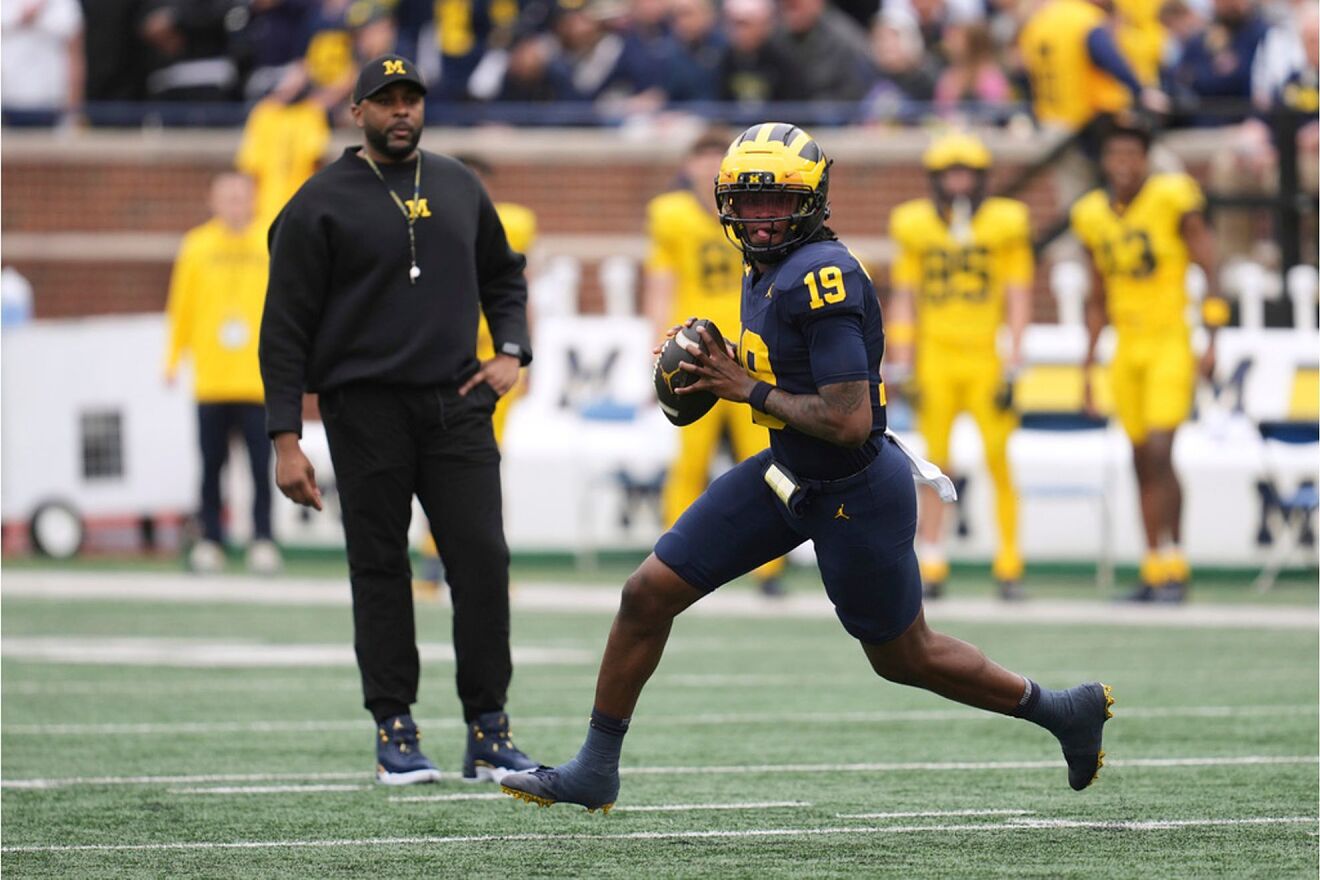 Michigan quarterback Bryce Underwood rolls out to throw as head coach...