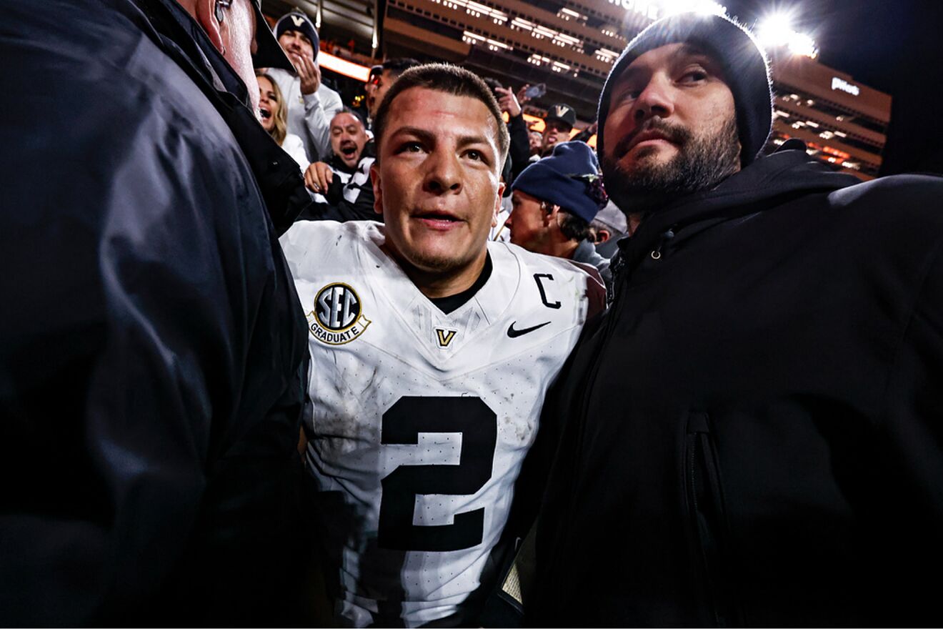 Vanderbilt quarterback Diego Pavia (2) is escorted back to the field...