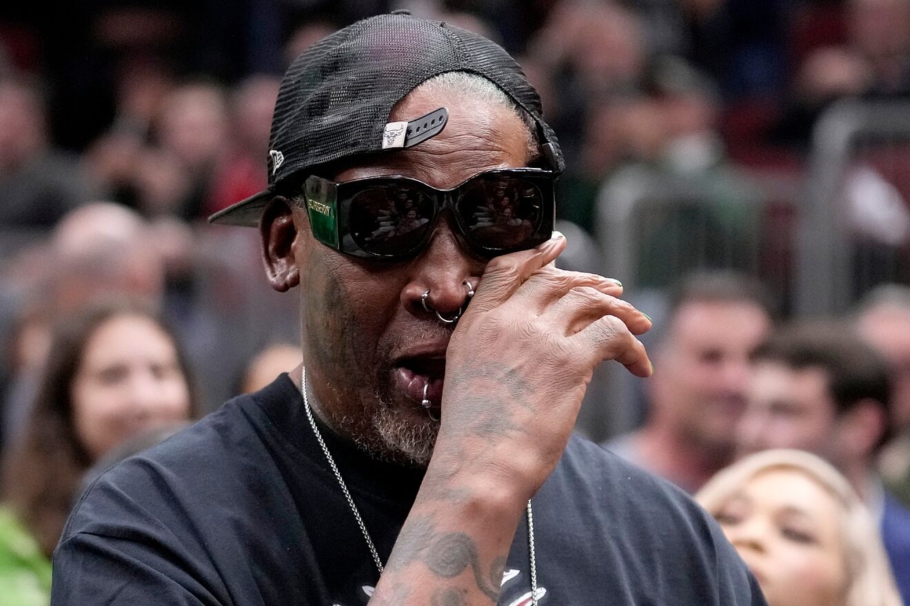 Former Chicago Bulls' Dennis Rodman wipes his eye and listens to the...