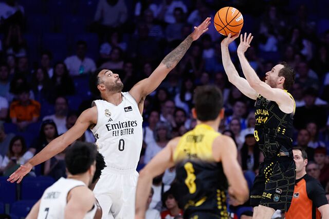 Marcelinho Huertas lanza un triple intentando evitar el tap�n de Trey Lyles.