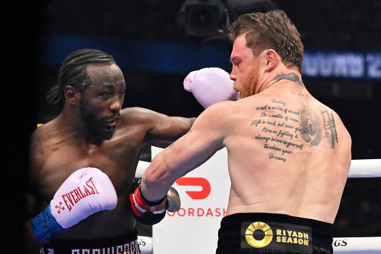 Terence Crawford punches Canelo Alvarez with a left hook during their...