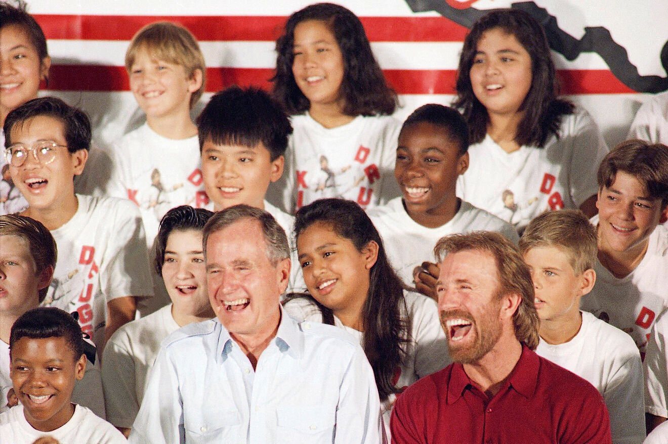 U.S. President George H. Bush sits with martial arts actors Chuck...