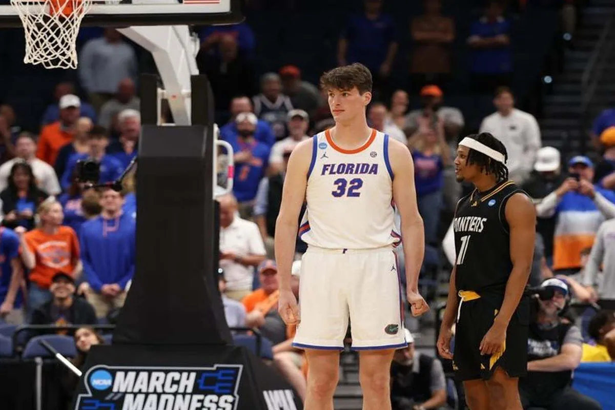 College forward finds himself in disbelief standing next to a giant during March Madness