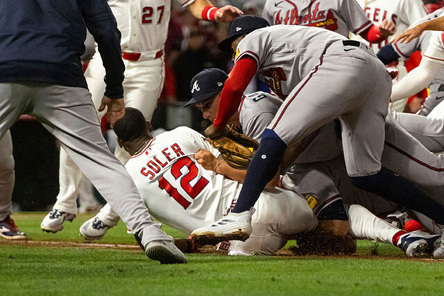 Jorge Soler (12) is tackled to the ground by Atlanta Braves players as a fight breaks out.
