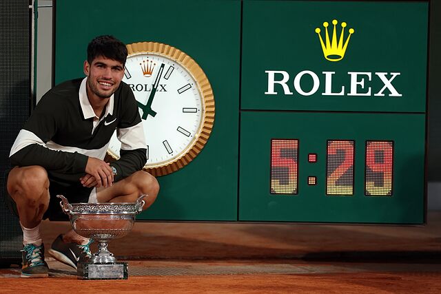 Carlitos posa con el reloj del tiempo de la final.