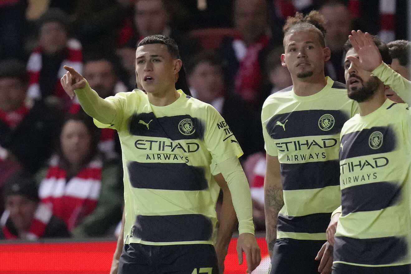 Manchester City's Phil Foden, left, celebrates with his teammates...
