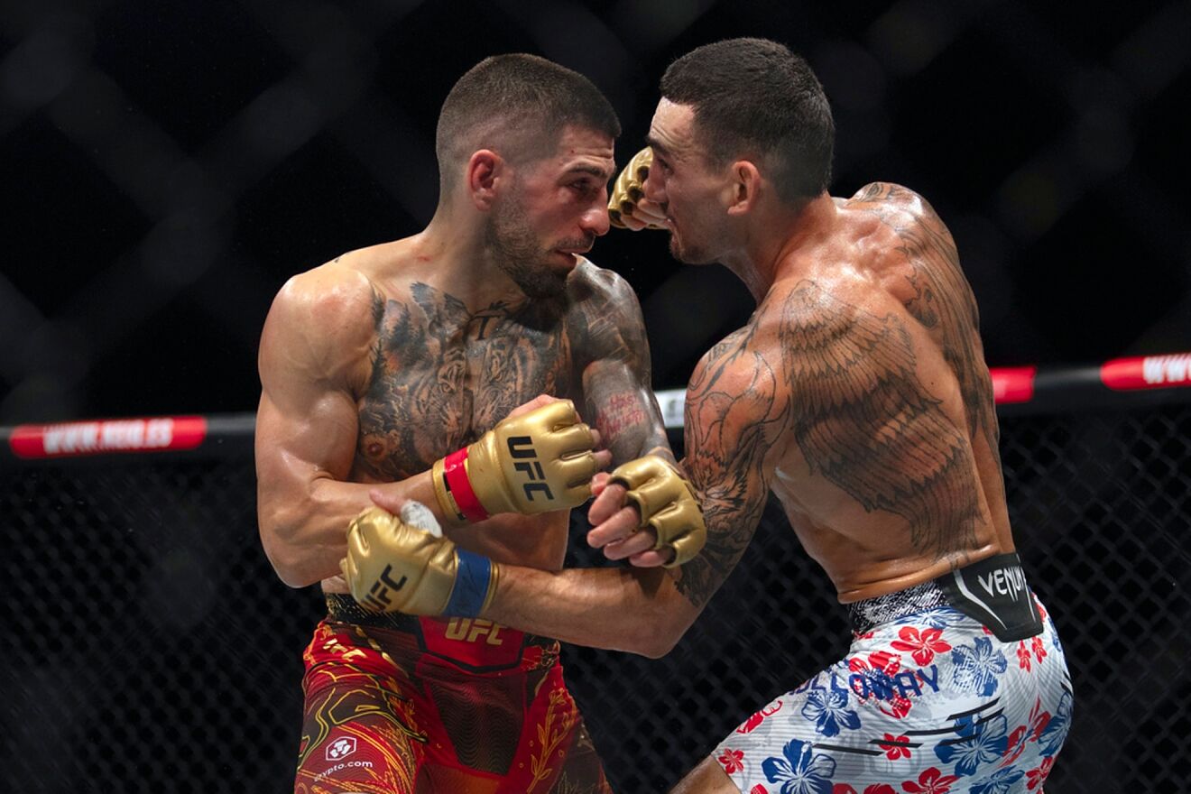 Topuria, left, battles Max Holloway during a mixed martial arts...