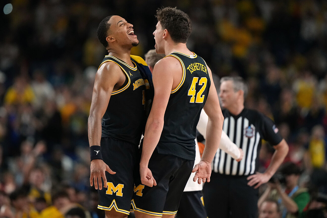 Michigan's Nimari Burnett, left, and Will Tschetter (42) celebrate...