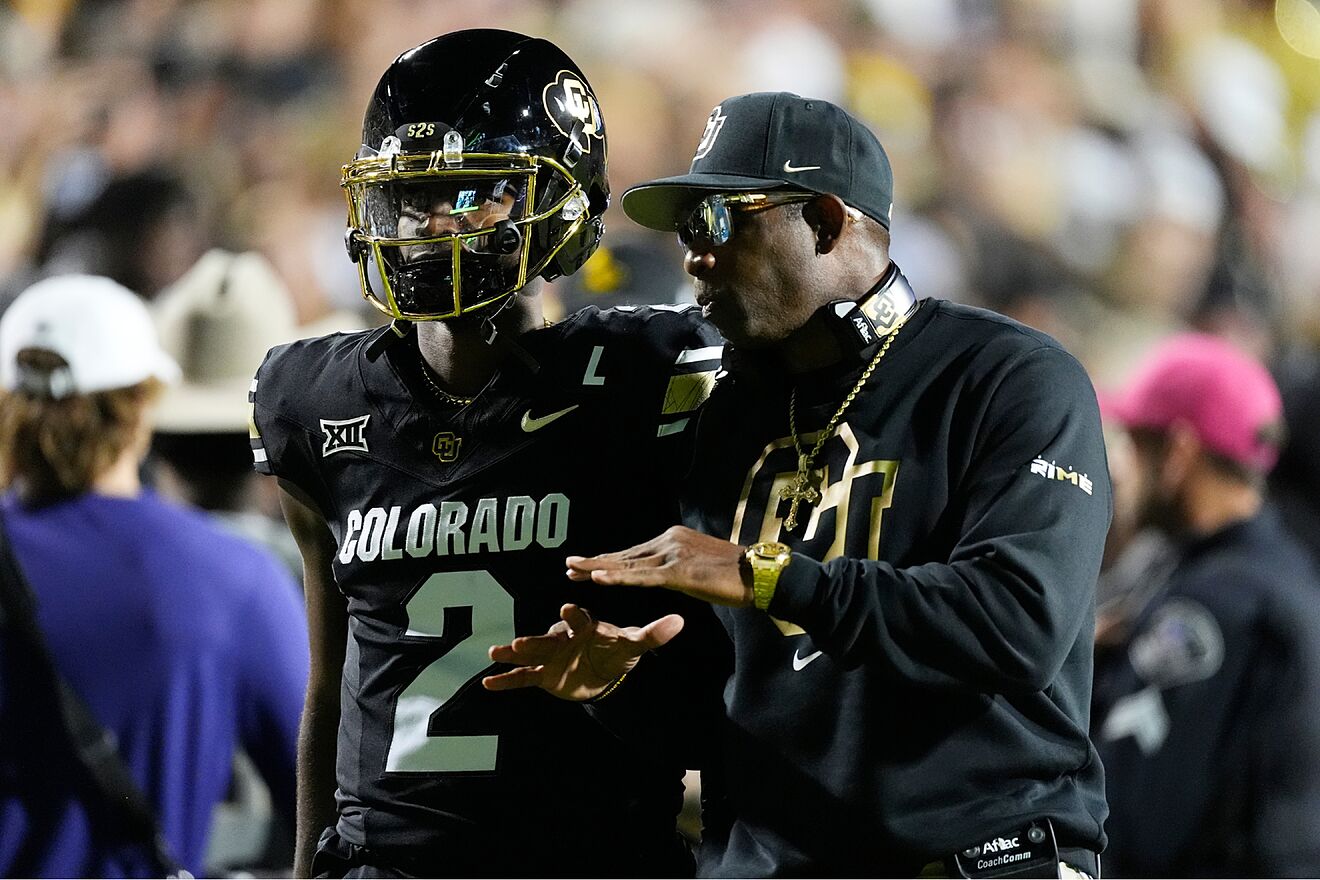 Shedeur and Deion Sanders speak during the Colorado-Kansas State game.