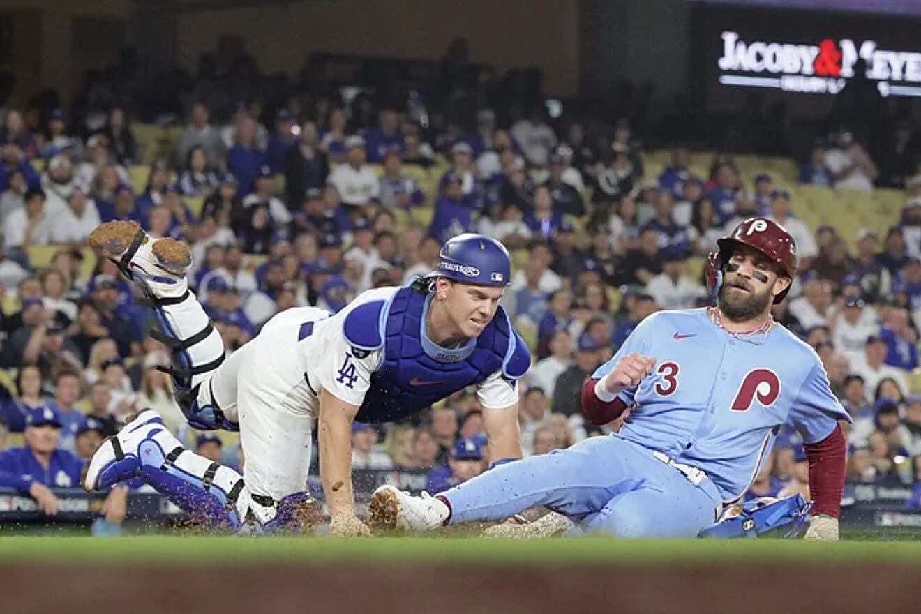 Bryce Harper (R) is tagged out at home plate by Los Angeles Dodgers...