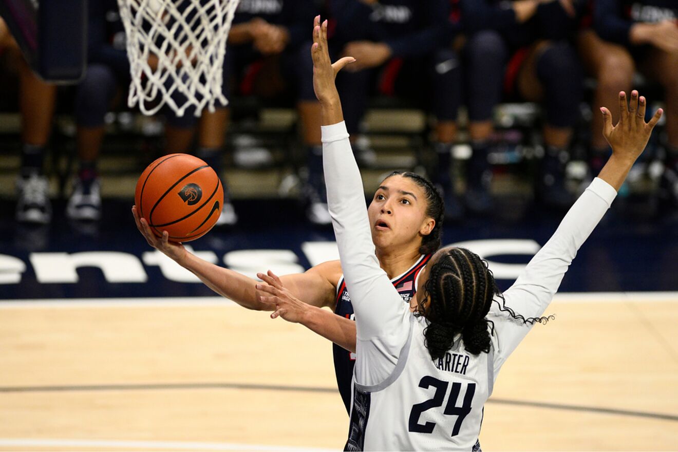 UConn guard Azzi Fudd, back, goes to the basket against Georgetown...