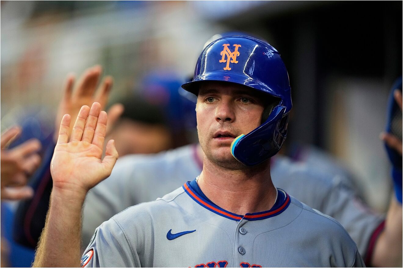 New York Mets' Pete Alonso (20) high fives in the dugout.